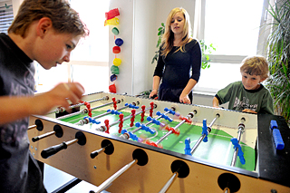 Drei Kinder spielen TischfuÃŸball