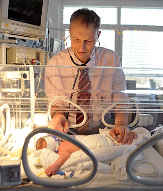 Dr. Wieg untersucht mit dem Stetoskop ein FrÃ¼hgeborenes im Inkubator